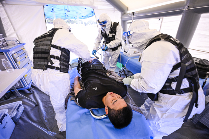9일 대구 수성구 대구스타디움에 설치된 국군대구병원 야전의무 텐트에서 화생방 보호장비를 착용한 의료진이 환자를 대상으로 응급 처치를 하고 있다. 이번 훈련은 육군 제50보병사단 주관으로 핵·WMD 상황을 가정해 민·관·군·경·소방 통합 대응 역량을 점검하기 위해 진행됐다.
이현덕기자 lhd@yeongnam.com 
