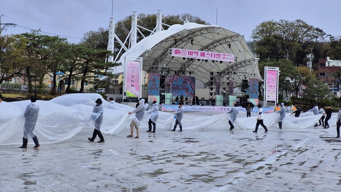 비가 그치자 상익회 회원들이 비닐을 걷어내고 있다. 이하수 기자