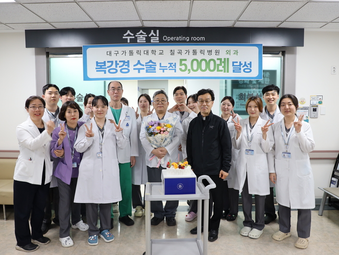 대구가톨릭대 칠곡가톨릭병원 외과 석상보 과장(앞줄 가운데 꽃다발을 든 이)이 복강경 수술 누적 5천례 달성을 기념하여 병원 관계자들과 함께 기념 촬영을 하고 있다.<칠곡가톨릭병원 제공>
