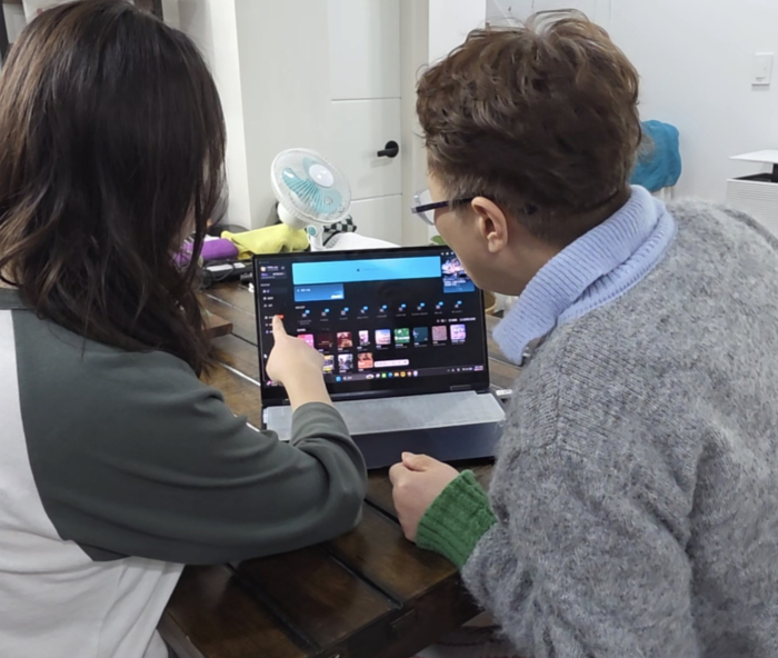 부모와 함께 거주하는 박민아(29)씨가 어머니 채성미(59)씨에게 편집 프로그램 사용법을 알려주고 있다. 박 씨는 고물가 상황에서 사회초년생이 부모와 함께 거주하는 것은 합리적인 선택이며, 서로에게 도움이 되는 부분도 크다고 말했다. 박민아씨 제공