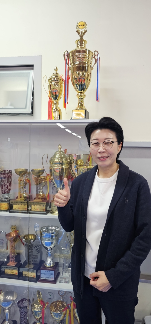 성주군청 여자태권도 선수단 박은희 감독이 우승 트로피 앞에서 엄지척을 하고 있다. <석현철 기자>