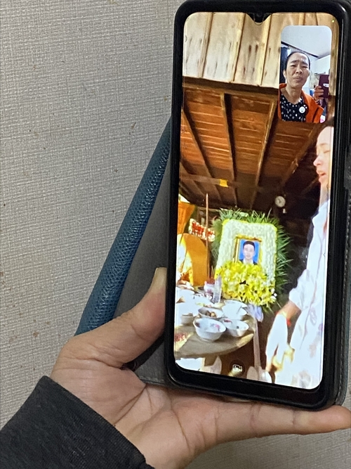 캄보디아에서 입국해 외국인 불법 체류자 신분으로 11년간 한국에서 생활한 마인씨가 휴대폰으로 아들의 장레식을 보고있다.<구미외국인노동자쉼터 제공>