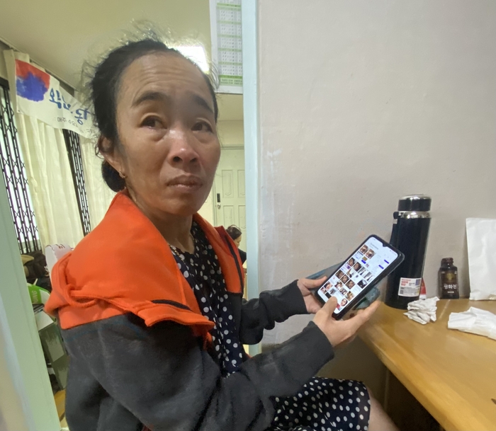 캄보디아에서 입국해 외국인 불법 체류자 신분으로 11년간 한국에서 생활한 마인씨가 휴대폰으로 아들의 장레식을 보고있다.<구미외국인노동자쉼터 제공>