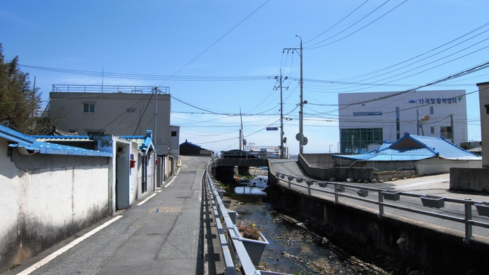 가곡항 입구에서 도로를 건너면 가곡천 골 따라 마을이 이어진다. 천변 울타리에 화분이 걸려 있다. 어촌뉴딜 사업으로 가곡천도 정비되었다.