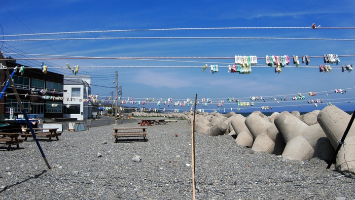 큰 방파제 북쪽으로 몇 채의 집이 이어지고 방파제 보강용 테트라포드가 마을을 보호한다.