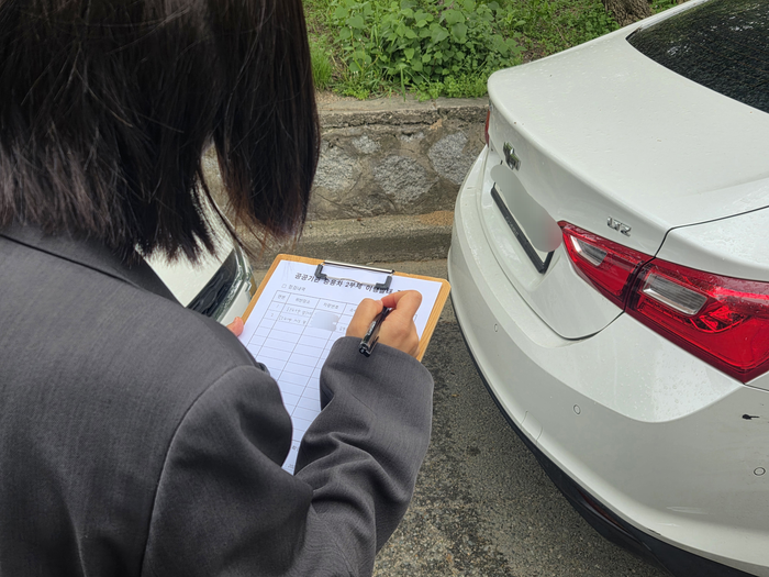 17일 오전 대구 수성구청 인근 골목길에서 공공기관 2부제 이행 실태 조사에 나선 녹색환경과 직원이 위반 차량을 적발해 명단을 작성 중이다. 최시웅기자