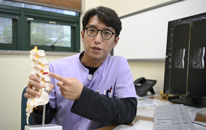 보광병원 여창기 진료 원장이 진료실에서 척추 모형을 가리키며 허리디스크 등 척추 질환의 발생 원인과 치료 방향에 대해 설명하고 있다. 이윤호기자 yoonhohi@yeongnam.com