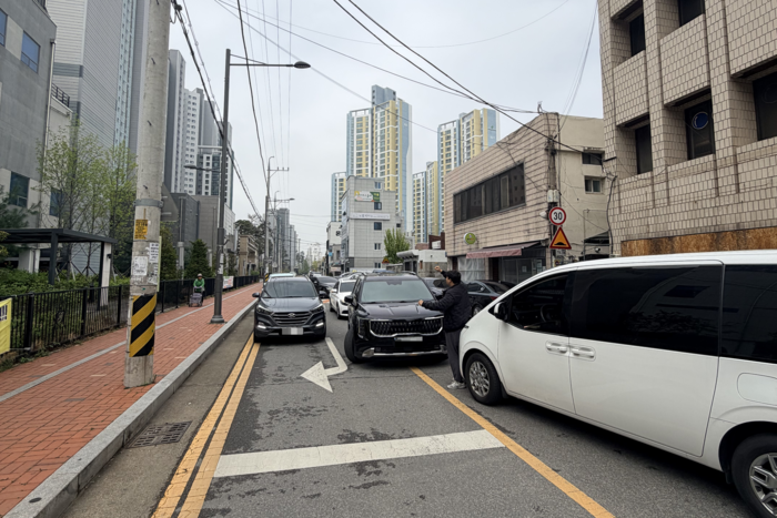 대구 수성구 중동의 A병원 주차장 진입을 기다리는 차량들로 인해 차량 통행이 원활하지 못한 모습. 인근 B아파트 주민들은 차량 대기열로 인해 중앙선 침범이 불가피하고, 교통 안전에 위협을 느낀다며  단체행동에 나선 상태다. <독자 제공>