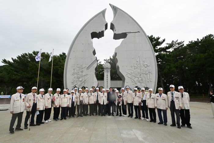 지난 2025년 장사상륙작전 전승기념공원을 배경으로 기념촬영을 하고 있는 장사상륙참전기념사업회 관계자 및 유격동지회원들(장사상륙참전기념사업회 제공)