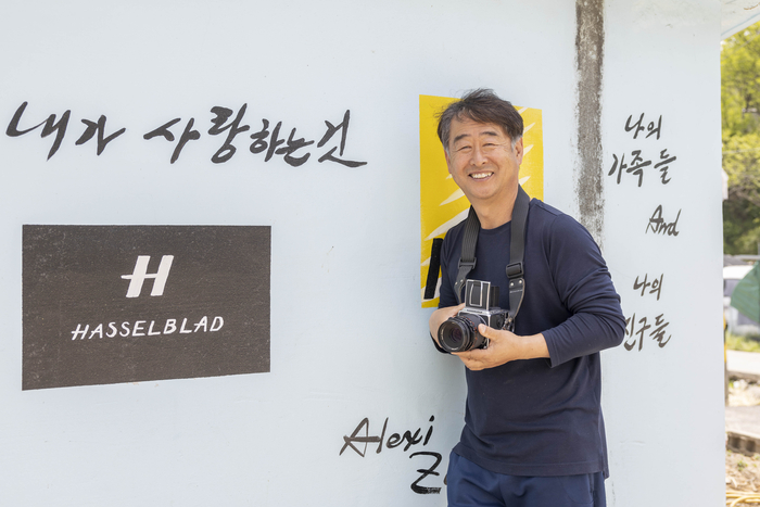 박준상 이장이 카메라를 들고 포즈를 취하고 있다. <마준영기자>