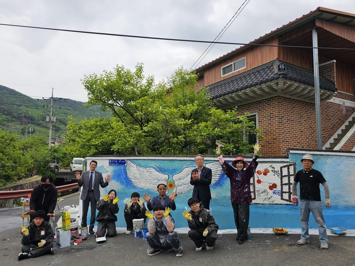 지난달 30일 청도 월곡마을 벽화작업에 참여한 벤자민인성영재학교 학생들과 교사, 안남숙 화가, 주민들이 기념사진을 찍고 있다. 한영화시민기자 ysbd418@hanmail.net