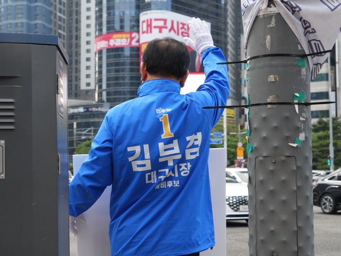 더불어민주당 김부겸 대구시장 후보가 14일 오전 수성구 범어네거리에서 출근길 차량들을 향해 인사를 하고 있다. <김부겸 후보 캠프 제공>