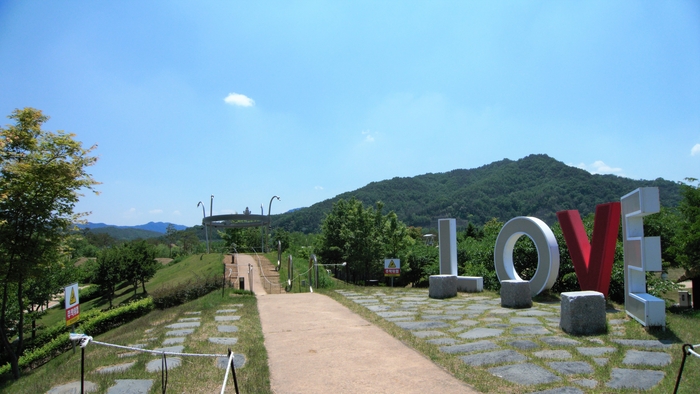 놀이터와 못 사이 방벽처럼 솟은 언덕길은 이름 거창한 백두대간 산책로다. 마루에 은빛왕관과 LOVE 포토존이 있다.
