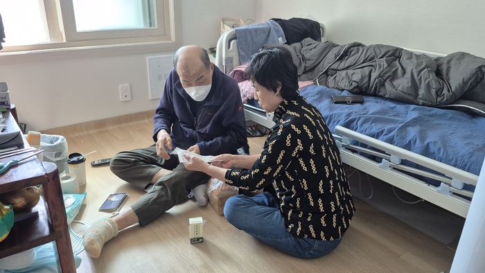 지난 21일 오후 대구 동구 율하동에 있는 최정식 어르신의 아파트에서 생활지원사 서유진 씨가 장을 본 영수증 내역을 설명하며 이야기를 나누고 있다. 조윤화 기자
