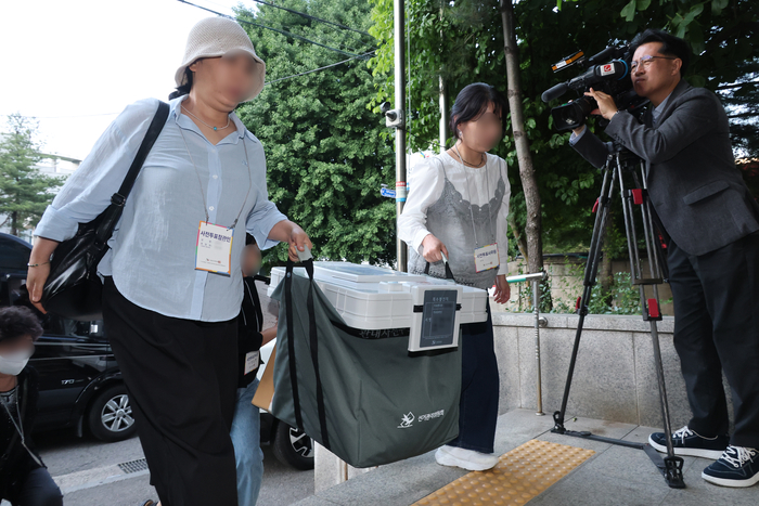 제9회 전국동시지방선거 사전투표 첫날인 29일 서울 용산구선관위에서 직원들이 관내사전투표함을 보관장소로 옮기고 있다. 연합뉴스