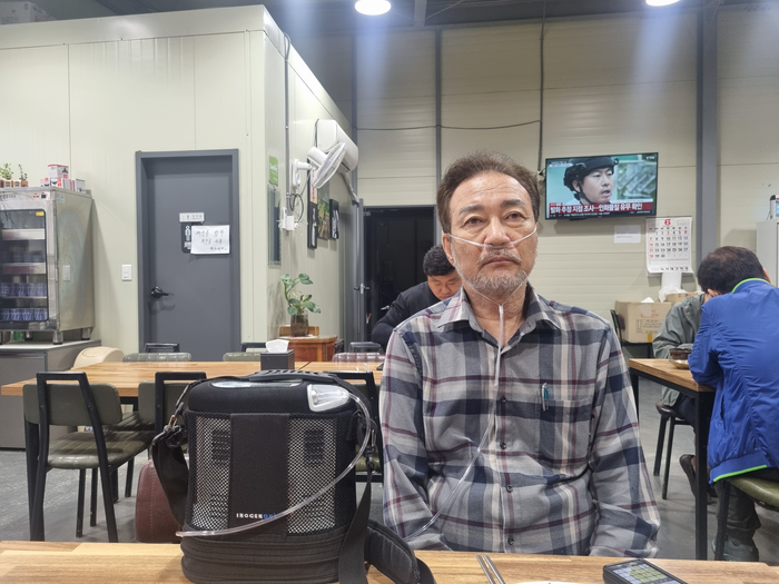 가습기살균제 피해자인 서영철(69·달성군 화원읍)씨가 산소 발생기를 착용한 채 앉아 있다. 서씨는 폐 기능 저하로 외출 시 산소 발생기를 항상 휴대해야 한다. 서영철씨 제공