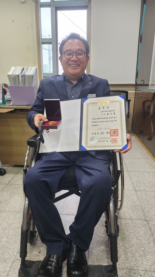 대통령 표창과 훈장을 보이며 포즈를 하고 있는 권순종 관장.<유시용 기자>