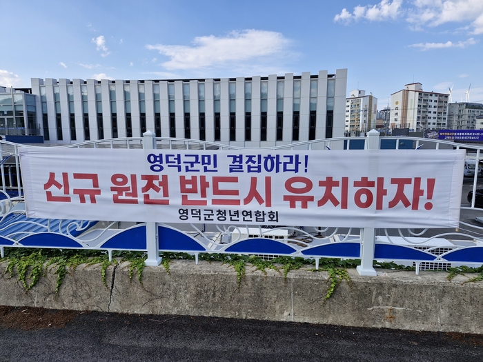 최근 개장한 영덕전통시장 인근에 게시된 신규 원전 반드시 유치하자 현수막. 한수원의 신규원전 예정지 확정 이후 지역사회에서는 미래 성장동력 확보와 일자리 창출에 대한 기대감이 커지고 있는 분위기다.<남두백 기자>
