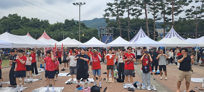 19일 오전 대구 수성구 수성못 상화동산 대형 스크린 앞에서 북중미월드컵 한국-멕시코전을 관람하던 시민들이 단체로 일어나 박수를 치며 열띤 응원전을 펼치고 있다. 이동현 기자