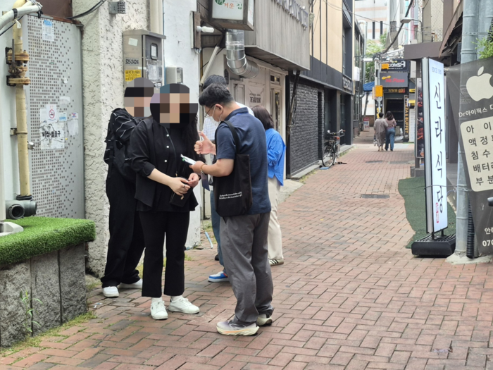 24일 오후 3시쯤 대구 중구 동성로 한 골목에서 금연구역 내 흡연으로 적발된 시민이 단속원으로부터 과태료 부과 안내를 받고 있다. 조윤화 기자