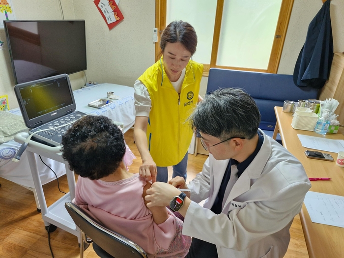 굳센병원 백승길 병원장(오른쪽)이 24일 경주시 산내면 일부리 경로당에서 어르신을 대상으로 어깨 관절 진료를 하고 있다.<굳센병원 제공>