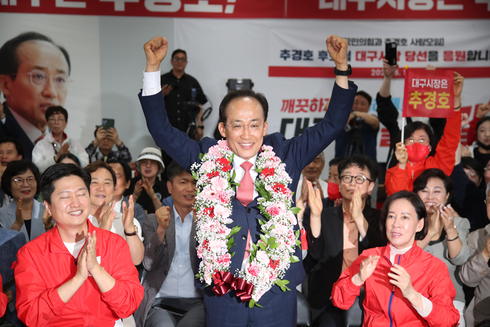 국민의힘 추경호 대구시장 후보가 당선이 유력시되면서 4일 오전 대구 범어네거리 선거사무소에서 축하 꽃다발을 목에 걸고 있다.  <연합뉴스>