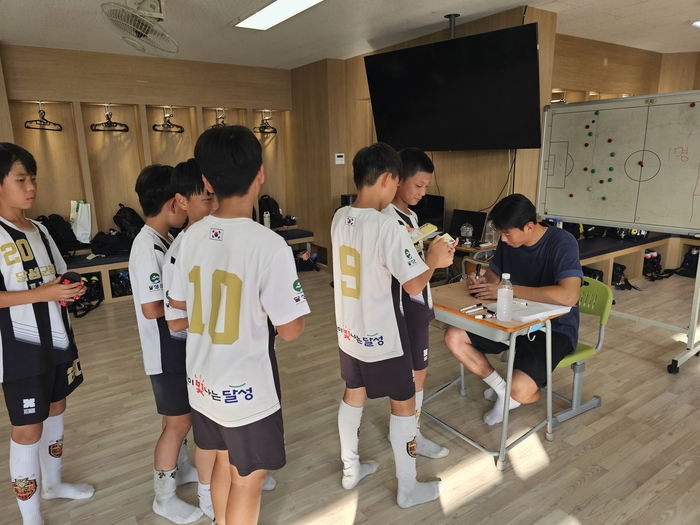 국가대표 수비수 이한범이 지난 6일 대구 달성군 화원초등학교를 찾아 달성군청 유소년축구단 선수들에게 사인을 해주고 있다.<영남일보 독자 제공>