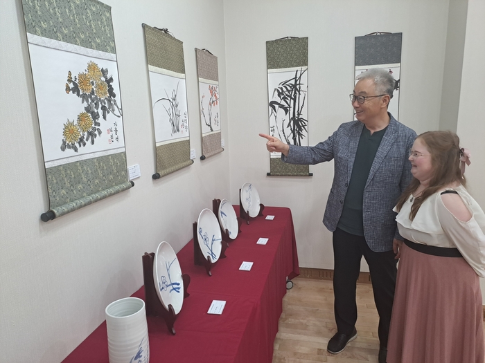 심천 이상배 선생(왼쪽)이 헝가리 카롤리 가슈파르 개혁교회대학교(Károli Gáspár University of the Reformed Church in Hungary) 한국학과에 재학 중인 야로 알렉산드라 씨와 함께 한국 서예·문인화 작품을 감상하며 작품의 의미와 표현 기법을 설명하고 있다. <강남진기자>
