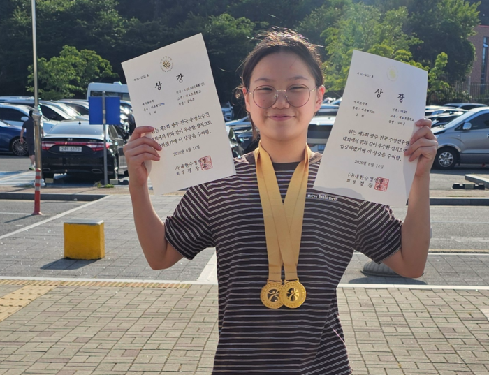 지난 10일 개막한 제5회 광주전국수영선수권대회에서 자유형 50m와 100m에 출전해 모두 1위를 한 김다은 선수가 상장 2개를 들고 환하게 웃고 있다.<김다은 선수 제공>