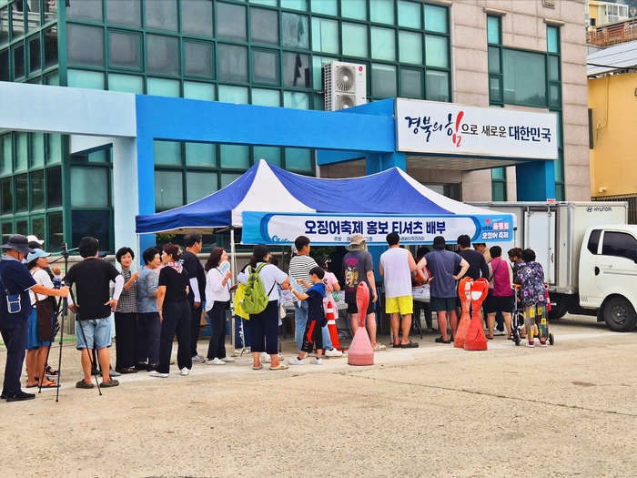 오징어축제 홍보 티셔츠 부스에 무더위에도 긴줄이 늘어서 눈길을 끌고 있다. <홍준기 기자>