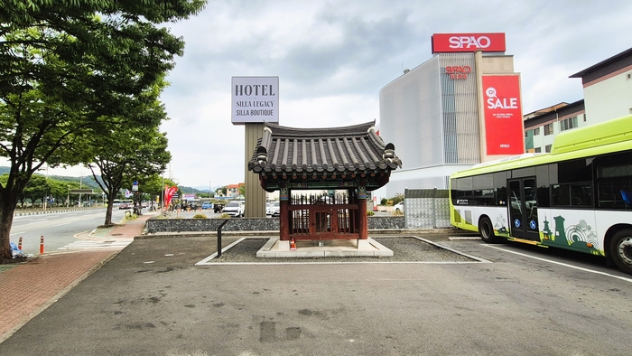 경주시 노서동 156-8번지 시내버스 대기장소 옆에 자리한 노서동 석불입상 비각. 주변이 미나리밭이던 시절부터 이곳을 지켜온 석불은 지금도 버스와 차량이 오가는 도심 속에 남아 있다. <장성재 기자>