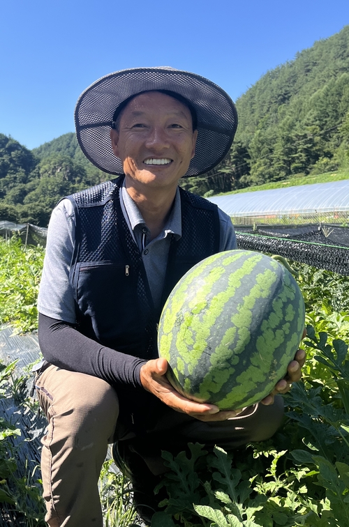 봉화군 법전면 소천1리 박상철 이장이 자신이 재배한 수박을 들어 보이며 환하게 웃고 있다. <황준오기자>