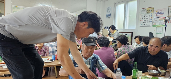 14일 말복을 맞아 마을회관에서 포1리 주민들이 함께 식사를 하는 가운데 김정훈 이장이 어르신들의 식사준비를 돕고 있다. 석현철 기자