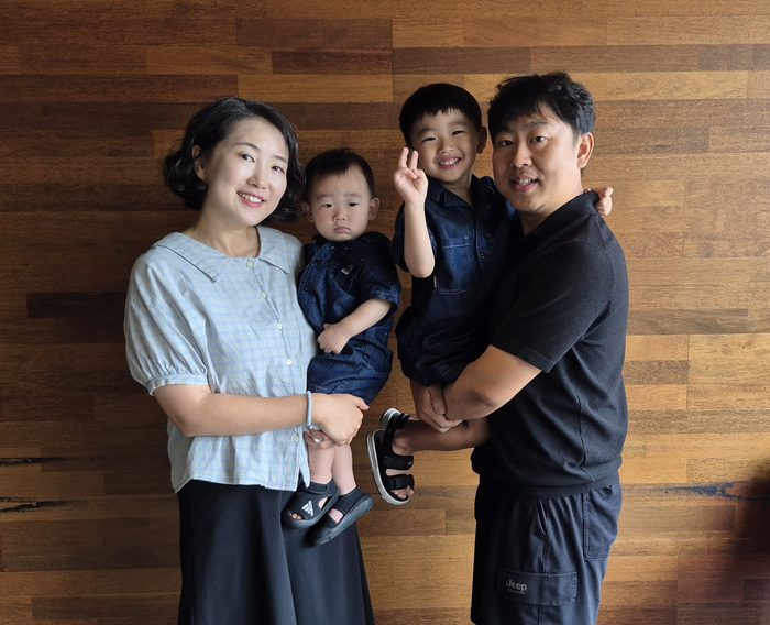 김현수·김명현씨 부부가 두 아들 김유현군(왼쪽 두 번째), 김이현군과 함께 환하게 웃고 있다. 부부는 두 아이의 첫돌을 맞아 돌잔치 대신 기부를 선택하며 가족의 나눔을 이어가고 있다. 조윤화 기자