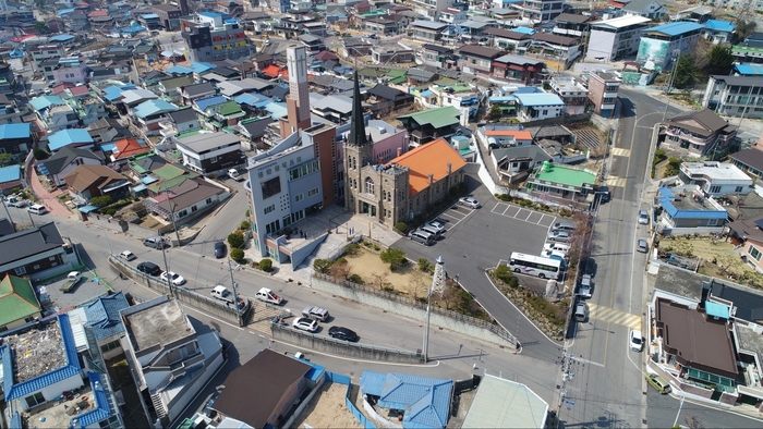 문경시 점촌동 도심 한가운데 자리한 점촌침례교회 예배당을 상공에서 바라본 모습. 주택과 상가가 밀집한 점촌 원도심 속에서 높게 솟은 첨탑과 석조 예배당이 뚜렷한 존재감을 드러내고 있다. 오랜 세월 도시의 성장과 변화를 함께해 온 점촌의 대표적인 근대문화유산이다. 강남진 기자
