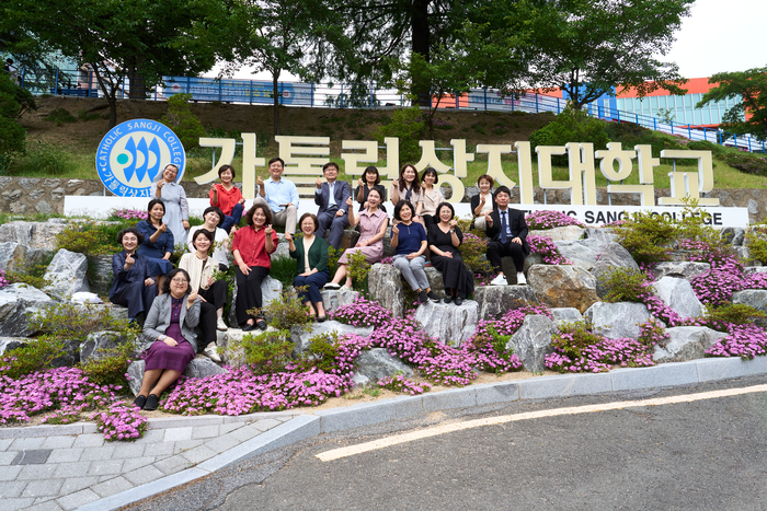 가톨릭상지대학교 교직원들이 교내 상징물 앞에서 대학 발전과 학생 중심 교육을 다짐하며 기념촬영을 하고 있다. 가톨릭상지대 제공