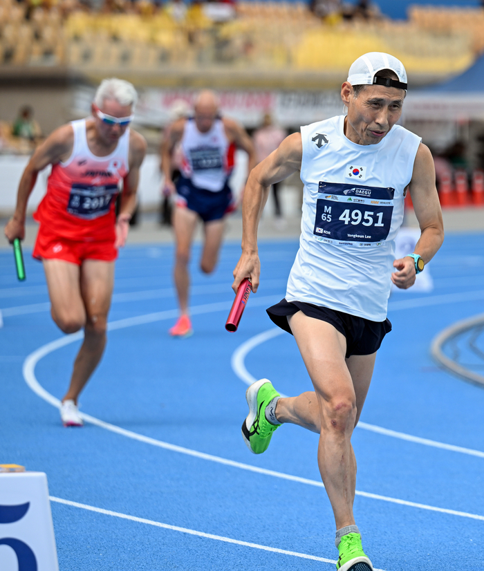 3일 오후 대구 수성구 대구스타디움에서 열린 2026 대구세계마스터즈육상경기대회 남자 60~64세부 4×400m 계주 결승에서 한국의 이영근 선수가 배턴을 이어받아 트랙을 달리고 있다. 35세 이상 생활체육 선수 1만1천여 명이 참가한 이번 대회는 지난달 21일 개막해 13일간 열전을 이어왔으며, 이날 폐회식을 끝으로 막을 내렸다. 정세영 수습기자