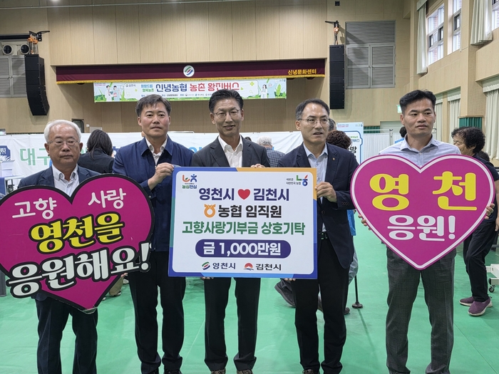 농촌왕진버스 운영 현장에서 김병삼 영천시장과 NH농협은행 영천시지부·김천시지부 관계자들이 고향사랑기부금 1,000만 원을 상호 기탁하고 기념촬영을 하고 있다. 영천시 제공