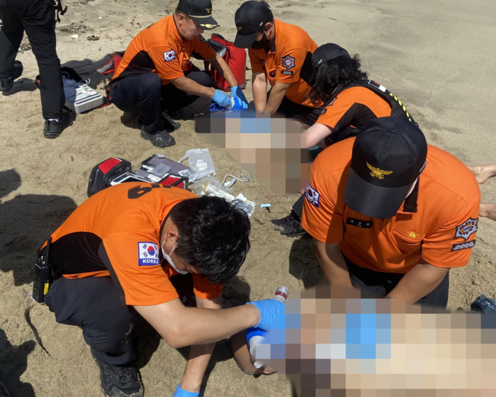울진 기성 바다인근 모래 사장에서 성인 남성 2명심폐소생술을 하고 있다. 소방본부 제공