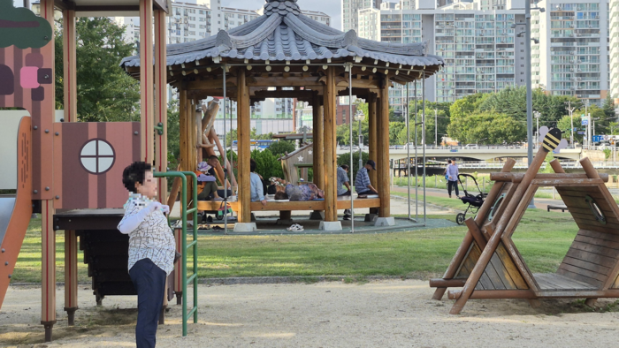지난 4일 오전 대구 신천변에서 한 시민이 체조를 하고, 인근 정자에서는 주민들이 휴식을 취하고 있다. 조윤화 기자