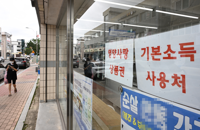 영양군의 한 가게 앞에 영양사랑상품권과 기본소득 사용처 안내문이 붙어 있다.