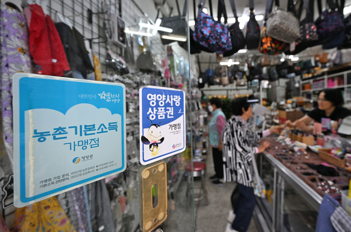 영양군 기본소득은 체크카드와 선불카드로 지급돼 지역사랑상품권 가맹점에서 사용할 수 있다. 영양군의 한 가게 앞에 영양사랑상품권과 기본소득 가맹점 스티커가 붙어 있다.