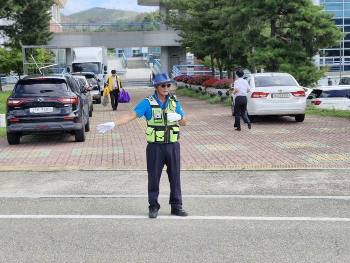 김상필씨가 영덕군민체육관에서 열린 2026 경북장애인한궁연맹 어울림대회 행사장 입구의 도로 위에서 차량 흐름을 살피며 교통정리를 하고 있다. 남두백 기자