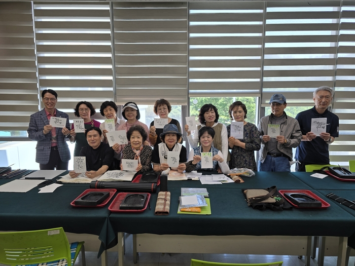 한 자 한 자 정성껏 만든 캘리엽서를 들고 동호회 회원들이 함께 웃고 있다. 김동 시민기자