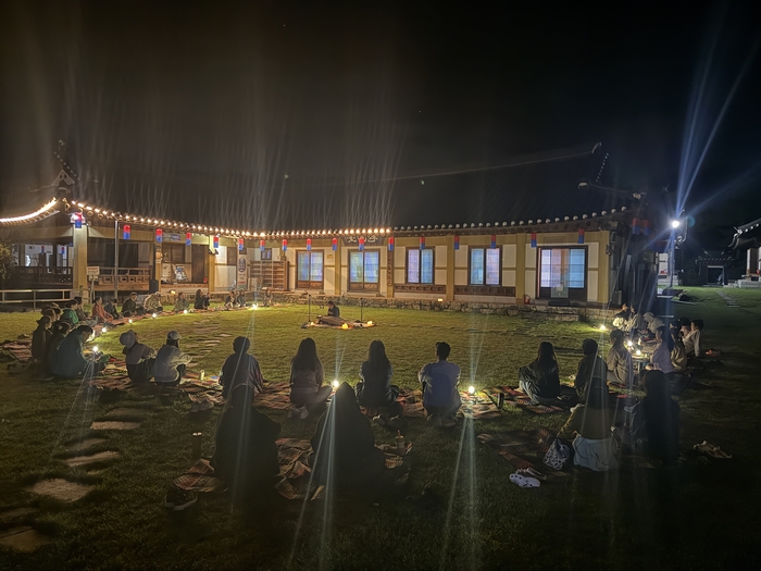 지난 12일 예천군 용문면 금당실힌옥체험관 마당에서 참가자들이 김희원 가야금 연주자의 연주를 감상하고 있다. 생텀 제공