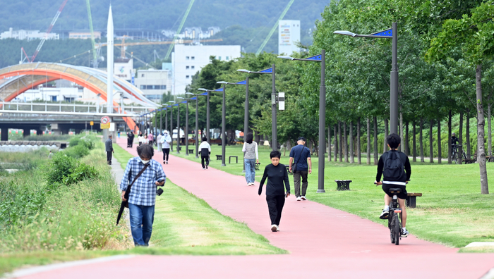 경산시는 남천에 파크골프장 등을 비롯해 시민들의 휴식공간을 조성해 접근성을 높였다. 시민들이 경산 남천 산책로를 걷고 있다.