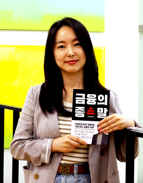 손혜민 작가가 얼마 전 출간한 책 금융의 종말을 들고 포즈를 취하고 있다. 그는 앞으로는 크립토와 AI가 지배하는 국경 없는 금융의 시대가 올 것이라며 한국의 금융도 이에 대비해야 한다고 주장했다. 박진관기자
