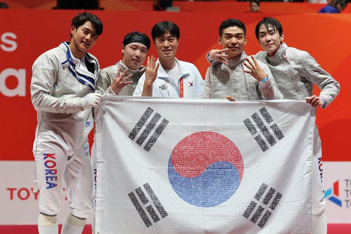 26일 일본 아이치현 도코나메 아이치 스카이 엑스포에서 열린 2026 아이치·나고야 아시안게임 펜싱 남자 사브르 단체 한국과 일본의 결승.  승리를 거둔 대한민국 선수들이 태극기를 들고 기념촬영을 하고 있다. 연합뉴스