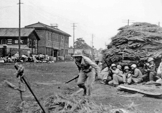 1946년 10월1일 대구 시위 발포 현장. 거리 한쪽에 장총으로 무장한 경찰들이 엄폐물 뒤에 쪼그려 앉아있고 반대편으로 피신한 시위군중 쪽에는 여러 명이 땅바닥에 쓰러져 있다. 미국 국립문서기록보관소 공개