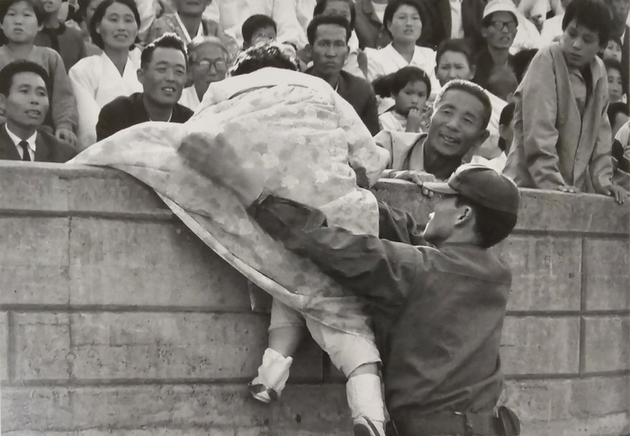 1972년 가을 대구에서 열린 전국민속예술경연대회 때 한복을 입은 아주머니가 담장을 넘어가는 모습이다.<장진필 대구원로사진가 제공>